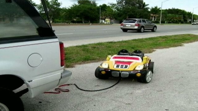 Risky ride: Couple tow granddaughter behind SUV in toy car