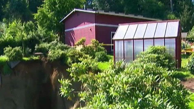 Couple watches yard disappear down 200-foot cliff