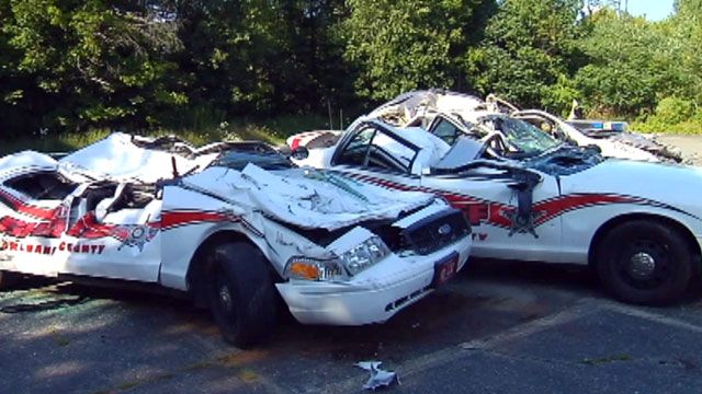 Police cars crushed by tractor