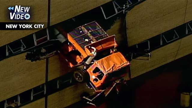 Truck Hanging Through Side of Building